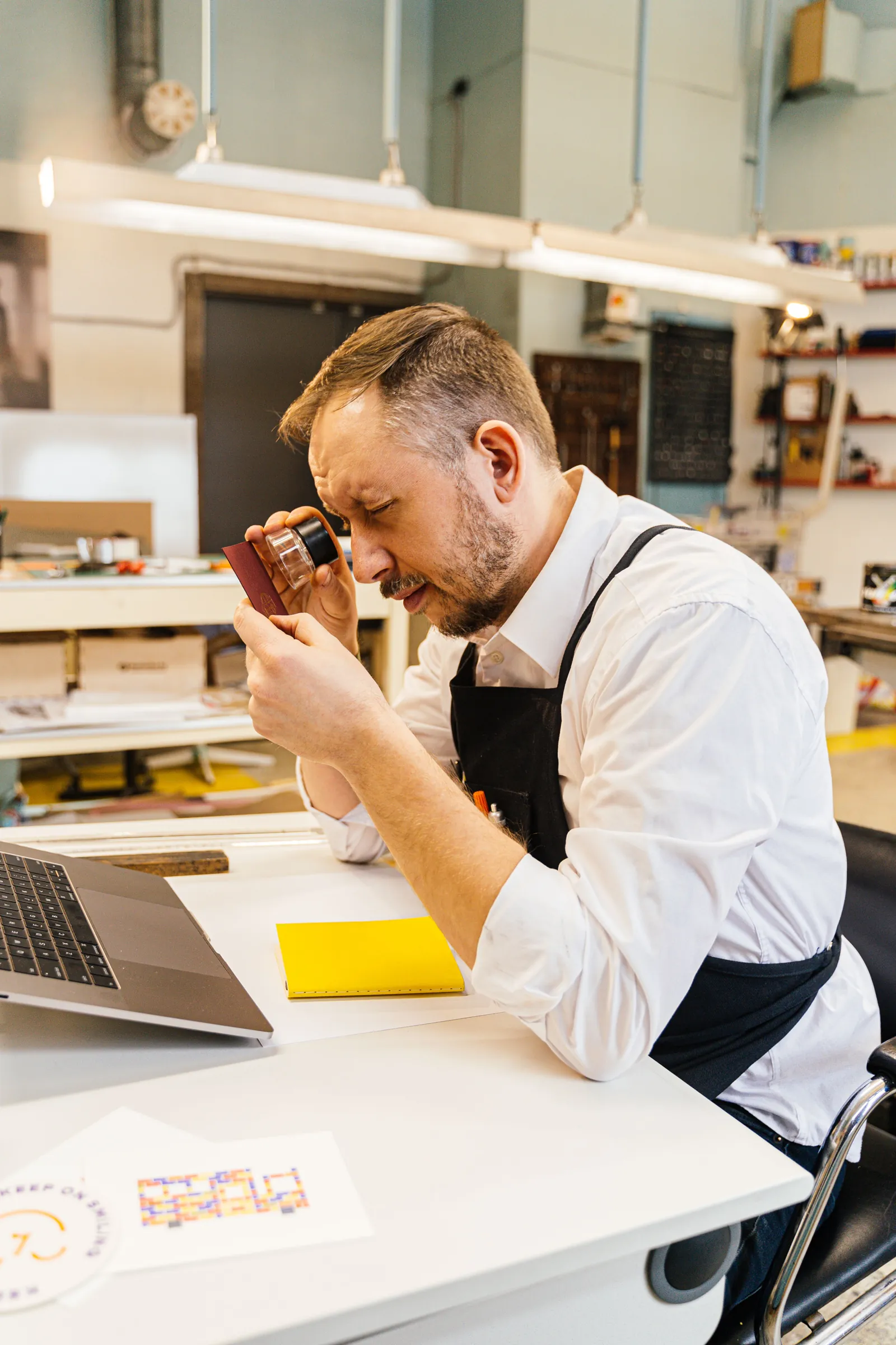 An auditor examining a document closely with a loupe