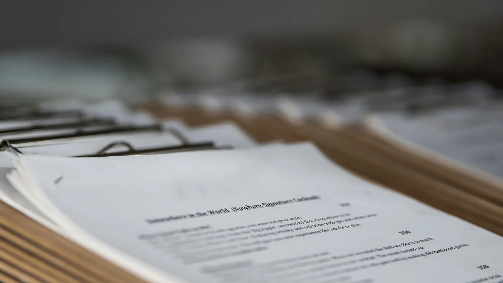 Printed documents clipped together on a wooden desk