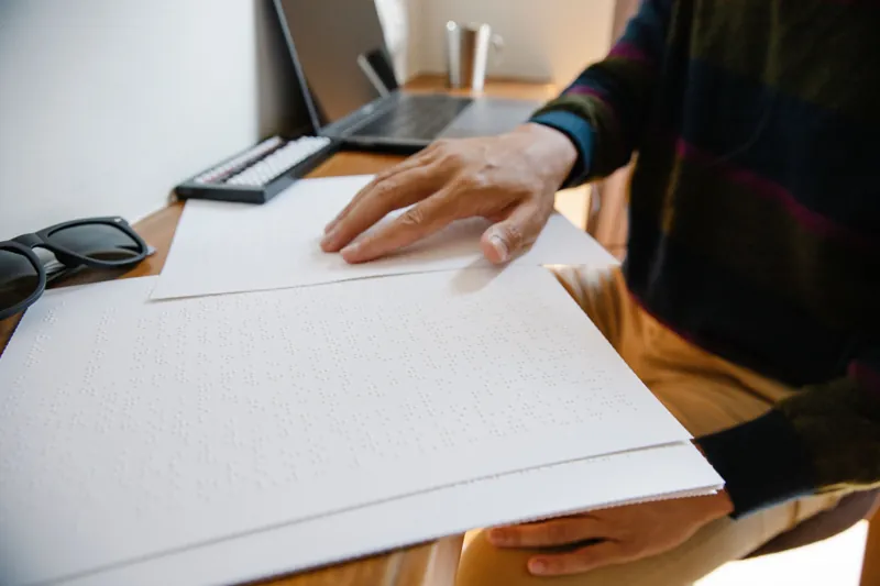 Hands reading a braille document